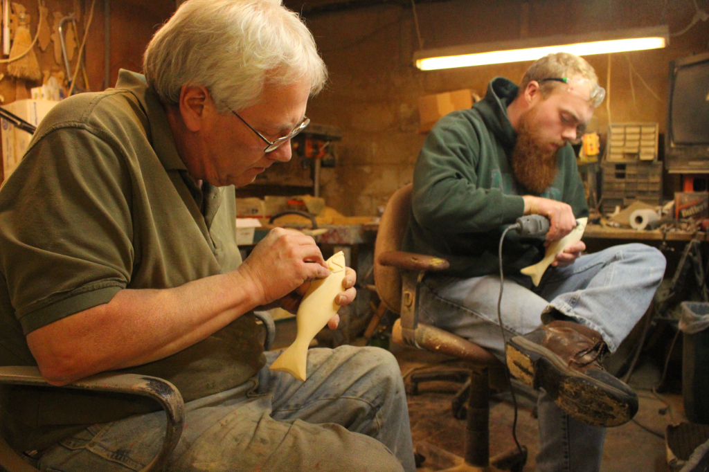 Rick Whittier and his apprentice working on carving fish decoys