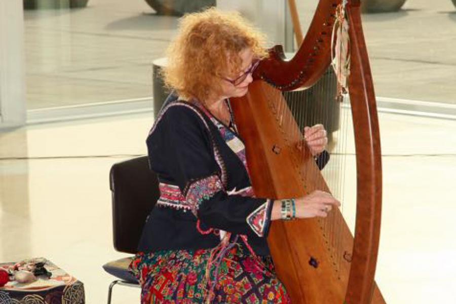 Photo of Debi Rogers playing the harp
