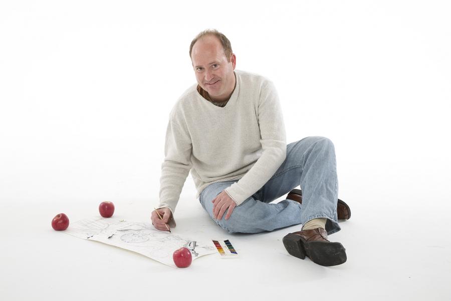Photo of Markus Tracy sitting on the floor and drawing on paper
