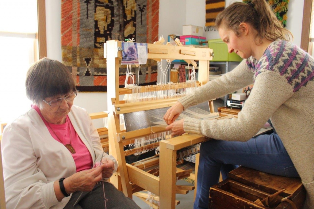 A photo of Finnish weaving master Annikki Martilla of Frederick, SD, and apprentice Sky Purdin of West Fargo, ND weaving together.