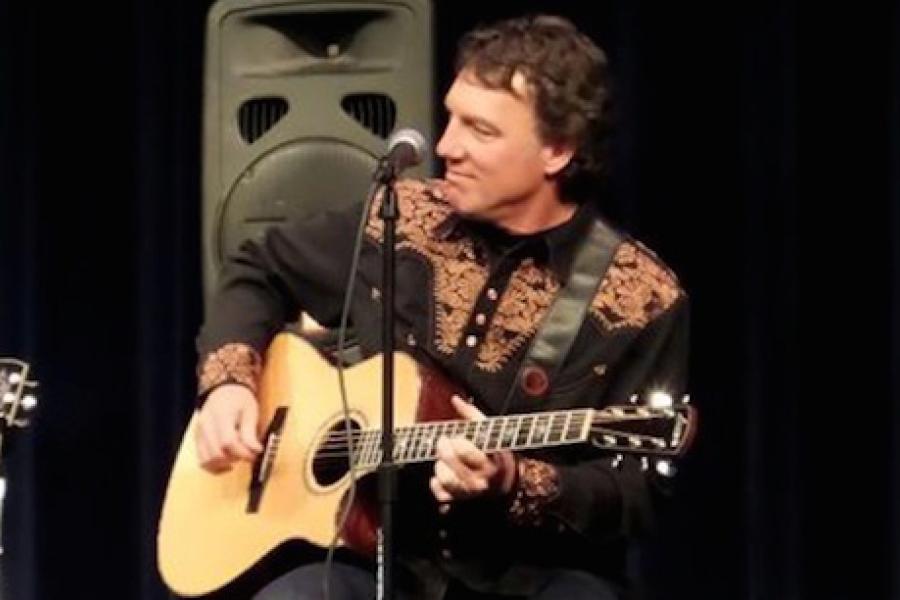 Photo of Monte Selby playing a guitar