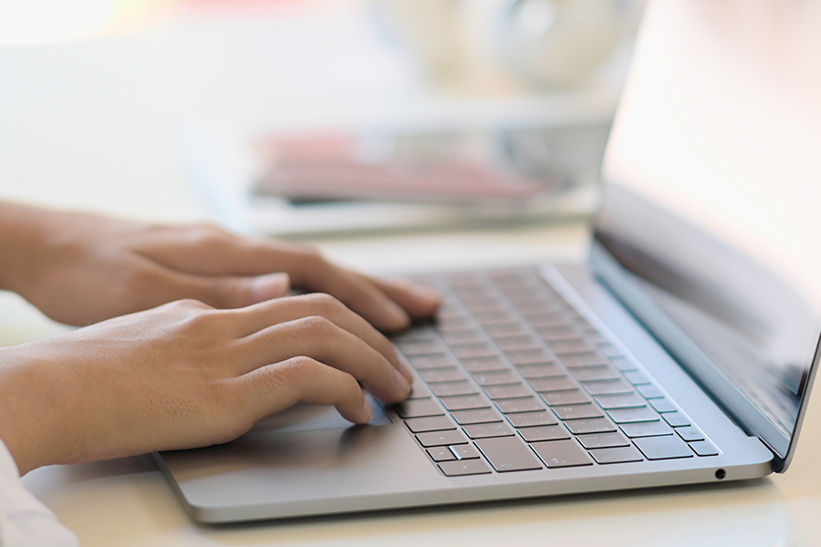hands typing on laptop