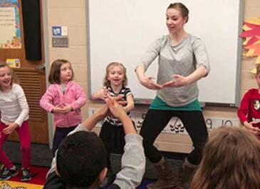 Photo of Northern Plains Dance dancer instructing young children