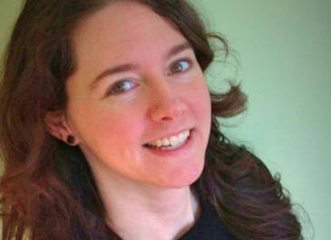 head and shoulders of artist Ali LaRock with thick flowing dark hair, and partial toothy smile that reaches her dark eyes