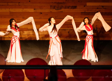 teaching artist Lexy Liu and two of her students in full dance attire performing Water Sleeve Dance