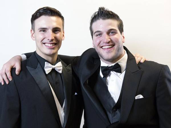 Head & shoulders of Matthew and Eric smiling, wearing black suit jackets with bowties