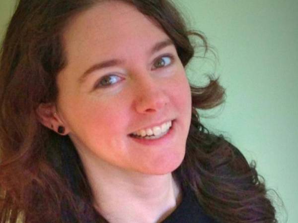 head and shoulders of artist Ali LaRock with thick flowing dark hair, and partial toothy smile that reaches her dark eyes