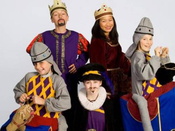 five actors wearing mid-evil costumes including crowns and bright colors