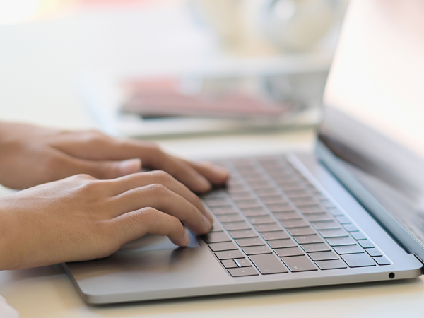 hands typing on laptop