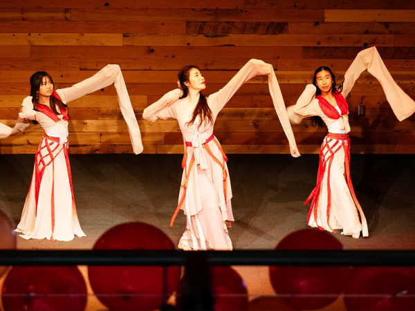 teaching artist Lexy Liu and two of her students in full dance attire performing Water Sleeve Dance