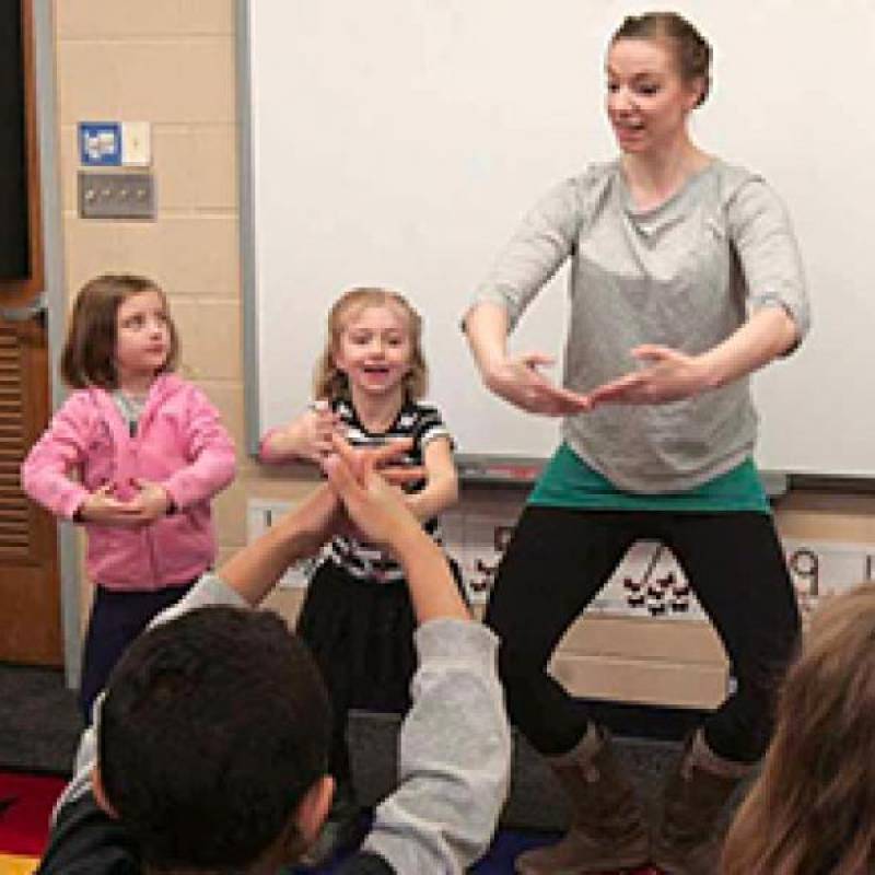 Photo of Northern Plains Dance dancer instructing young children