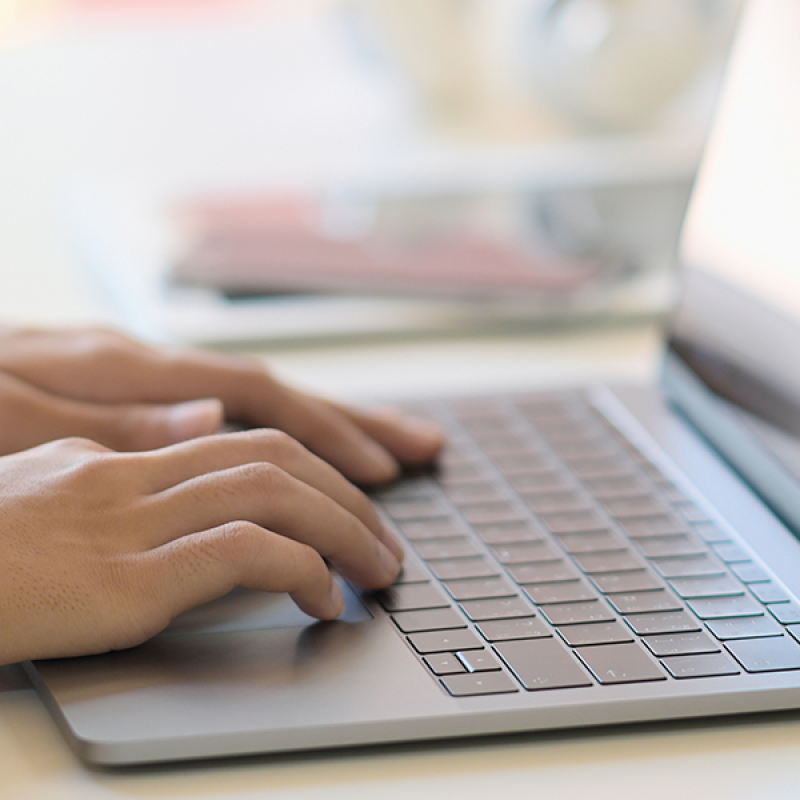 hands typing on laptop