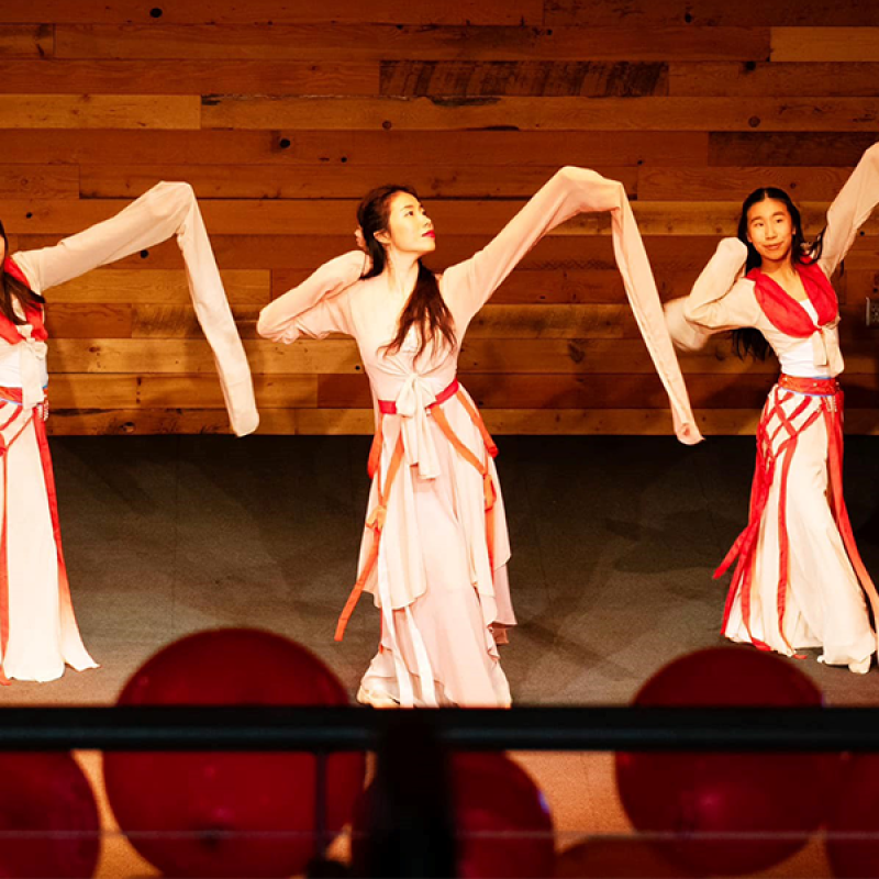 teaching artist Lexy Liu and two of her students in full dance attire performing Water Sleeve Dance