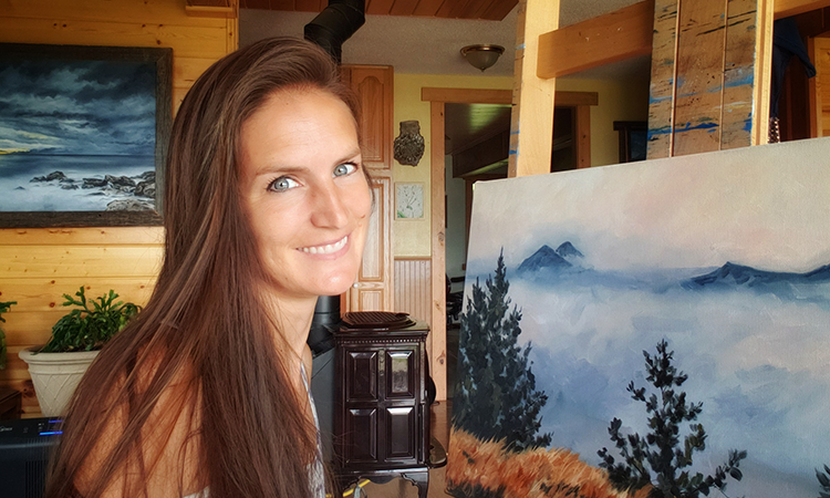 Head and shoulders of painter Katrina Case in her studio next to a landscape painting