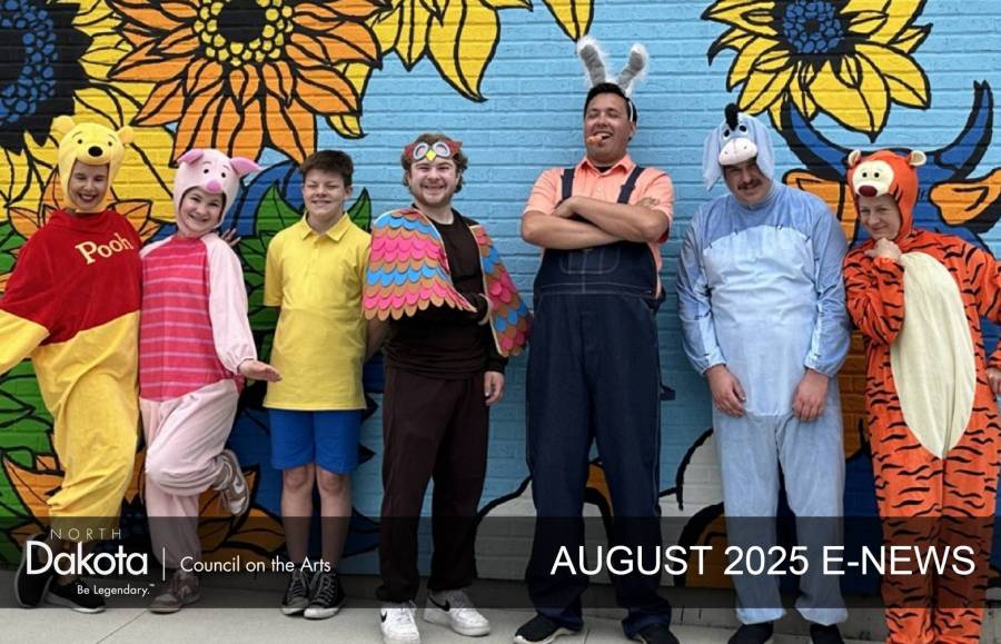 Performers from the youth-focused production of Winnie-the-Pooh pose in front of the West Fargo mural.