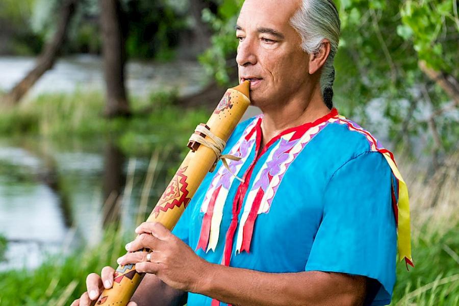 Photo of Kevin Locke playing a wooden hand-carved flute