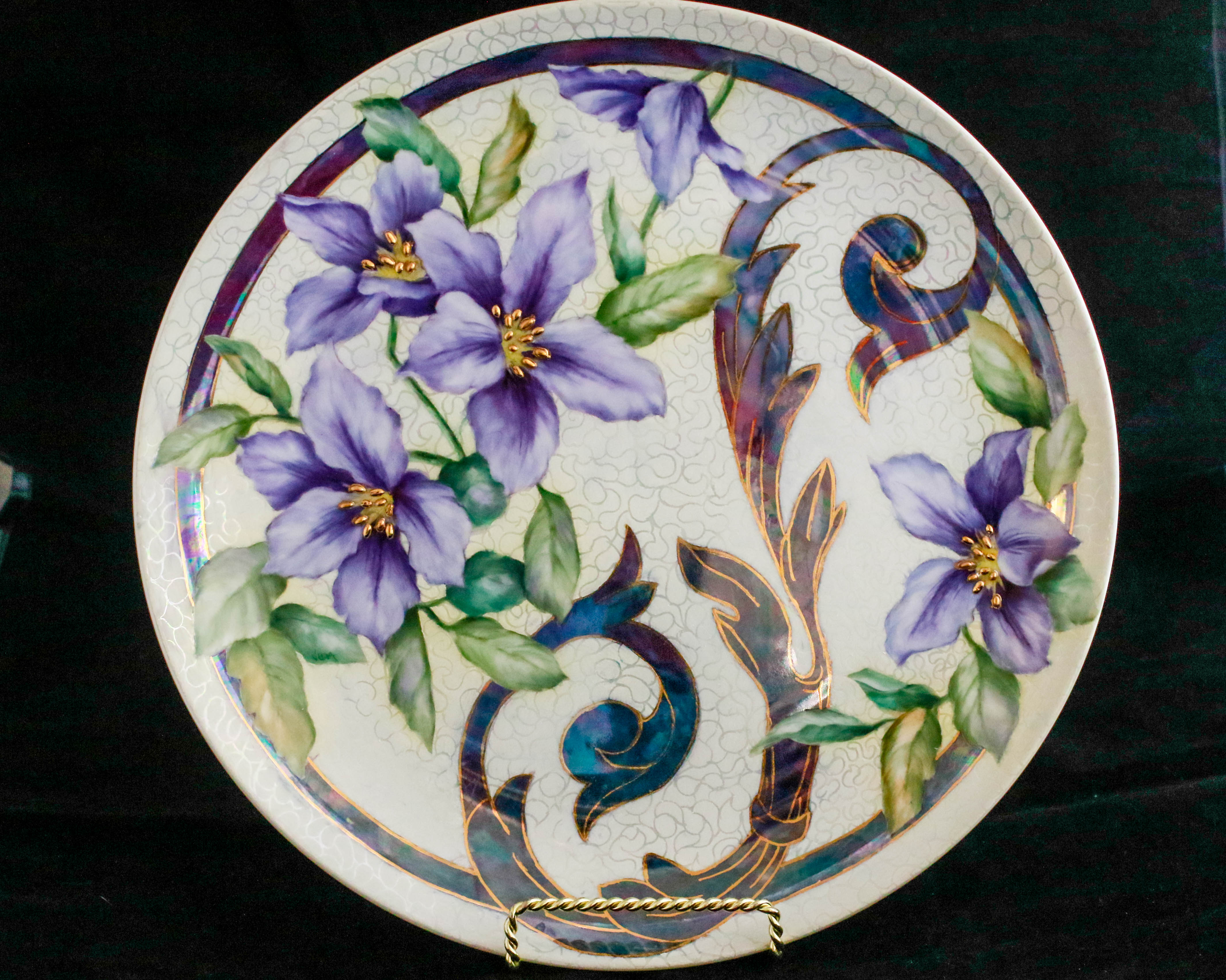 Round porcelain plate, intricately painted with flowers and vines
