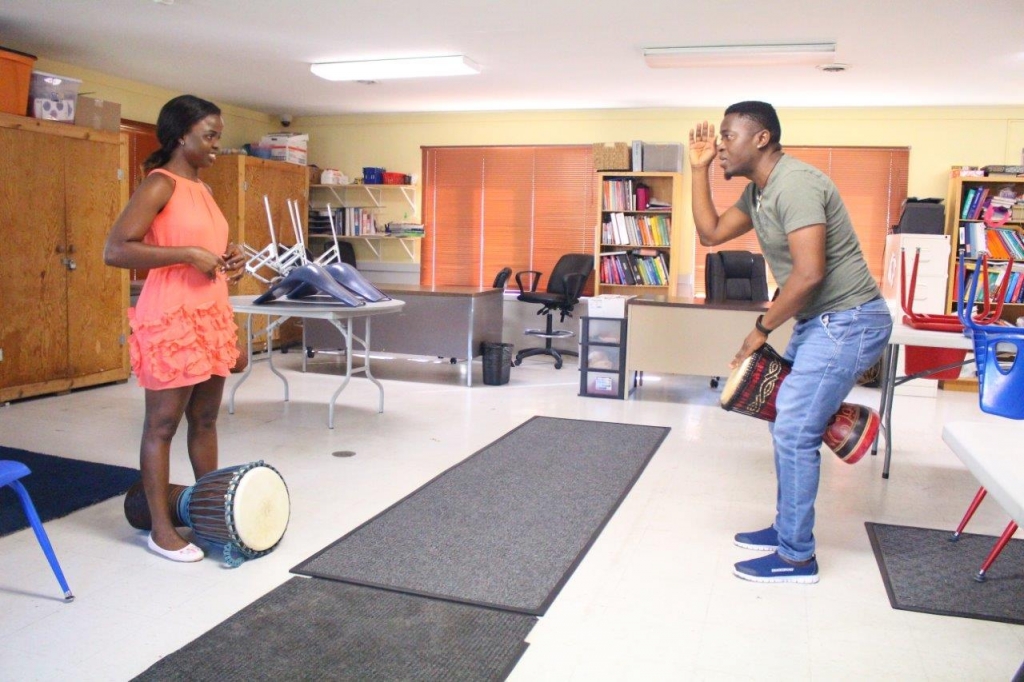  A photo of Master West African drummer/storyteller Hamzat Koriko and apprentice Dorothy Assongacha, Grand Forks, ND drumming together.