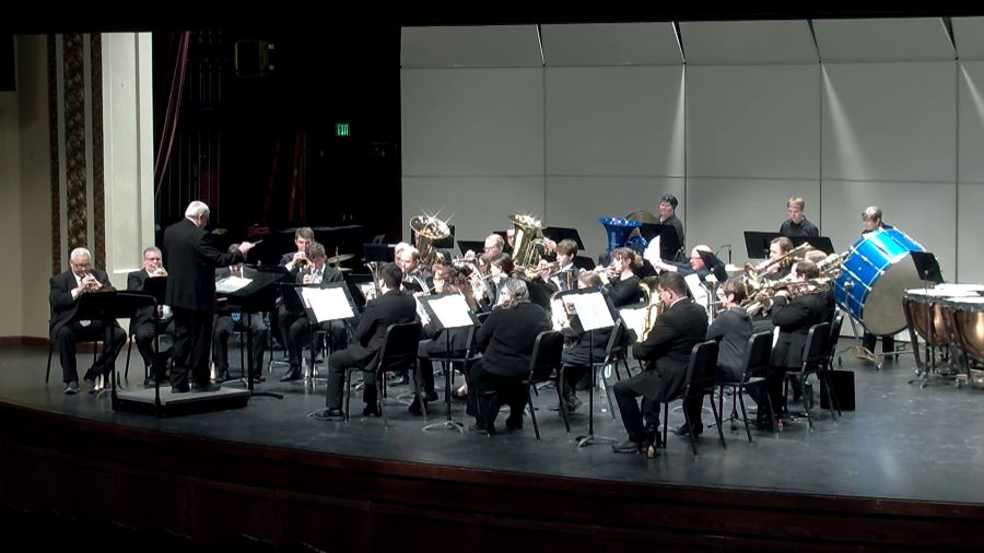 Band players sitting on a stage, playing instruments