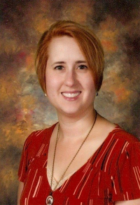 Cynthia McGuire Thiel wearing a red patterned v-neck shirt, with light skin, ear-length red hair, big toothy smile, with colorful backdrop