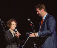 Laurel Reuter speaking in microphone with Matthew Wallace to her right