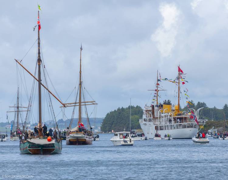 Many Norwegian ships, boats, and a larger cruise ship with many people on board; on Oslo Harbor in Norway on an overcast day in July, 2025