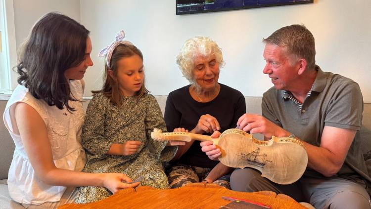 Four generations, matriarch-son-granddaughter-great granddaughter, of the Norwegian Hodal family, from Fargo/Moorhead, all doing some sanding on the 2025 Commemorative Hardanger fiddle, marking 200 years since the first group of Norwegians immigrated to the US
