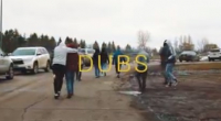 Students walking away outside on a paved road with cars parked around them, during a cold winter day in Fort Totten, North Dakota