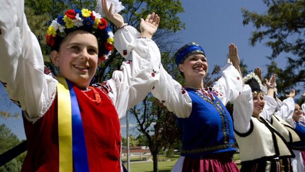 ND Ukrainian Dance Association dancers in uniform, smiling with arms up