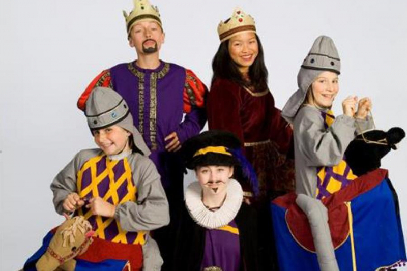 five actors wearing mid-evil costumes including crowns and bright colors